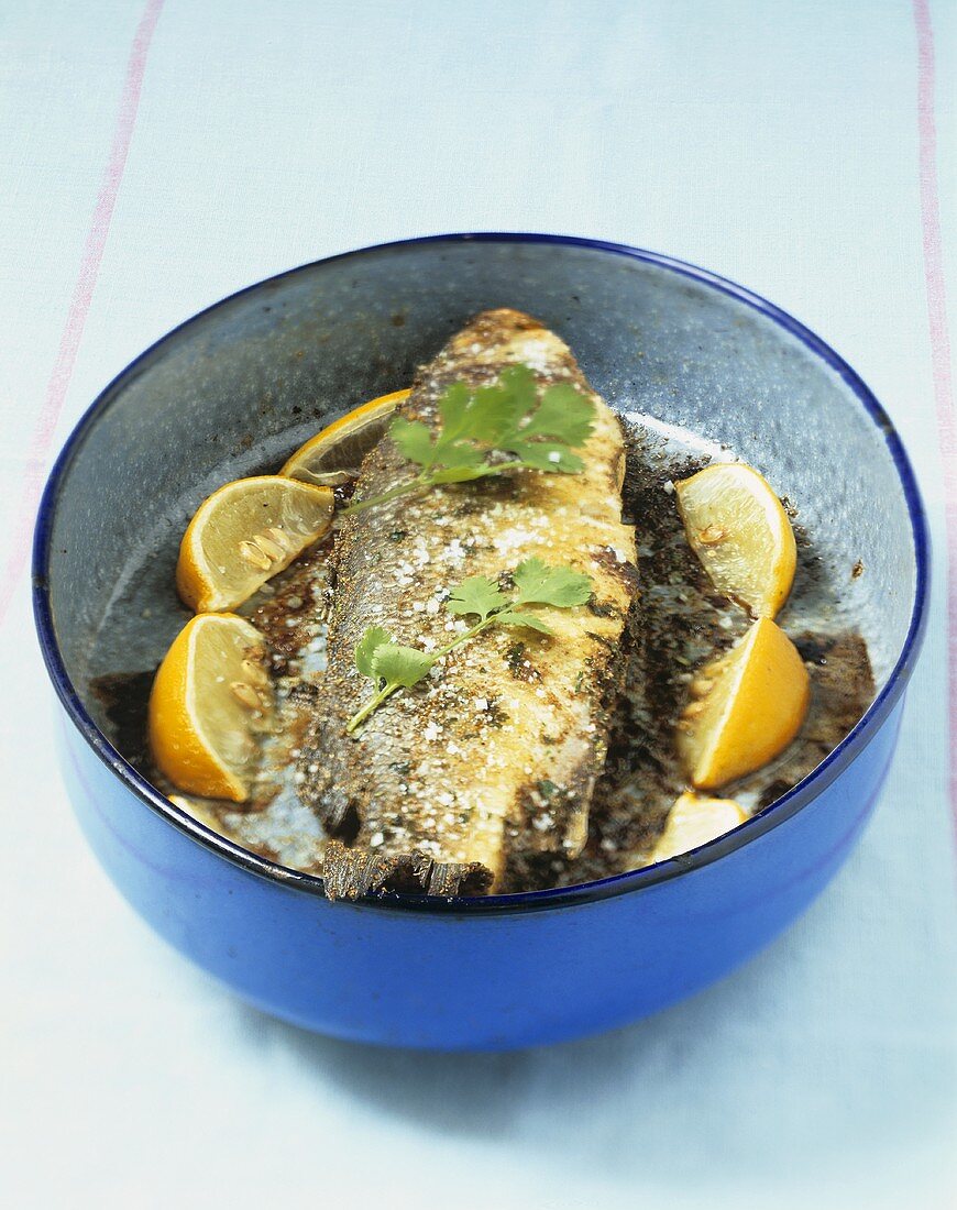 Sea bass with coriander and lemon wedges
