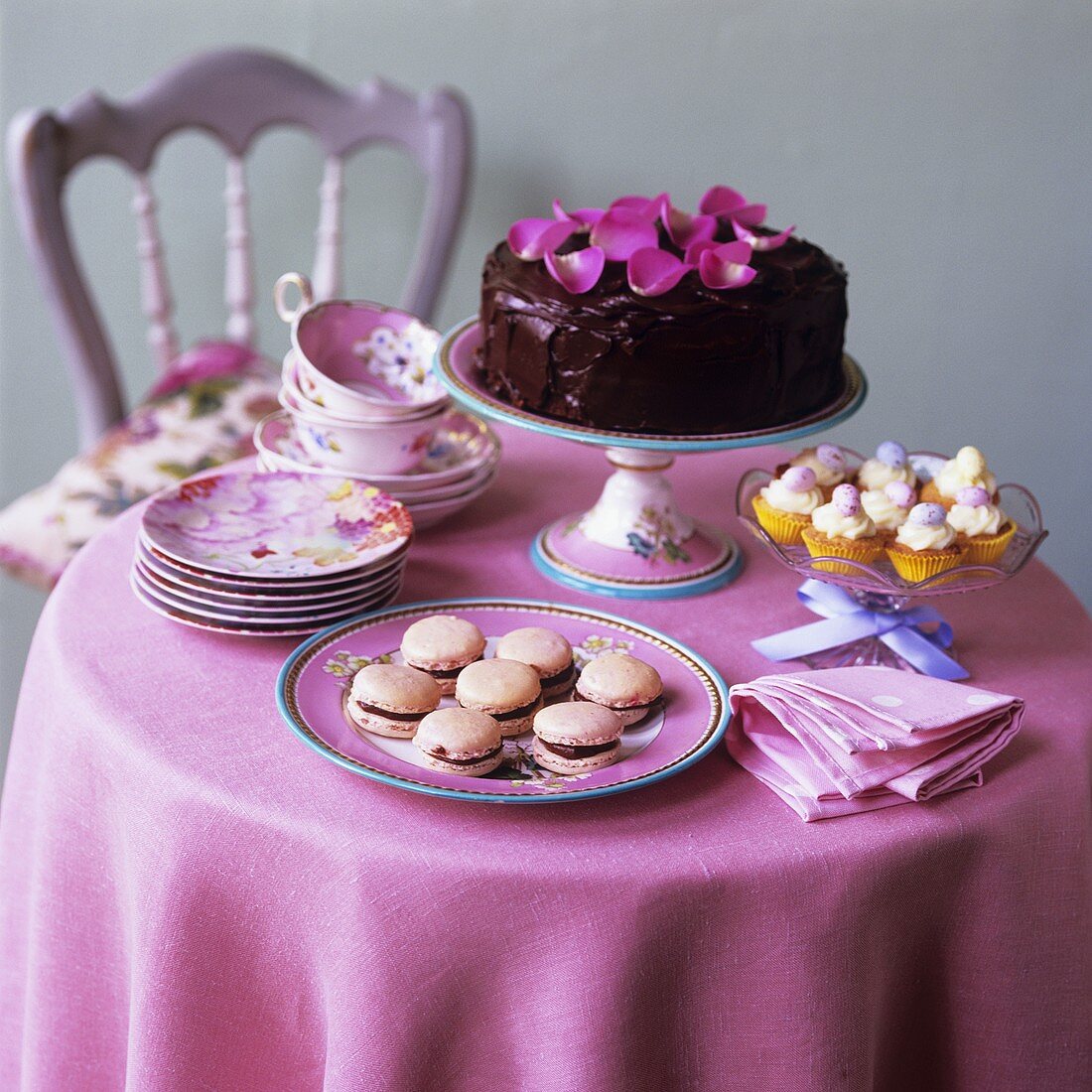 Schokotorte, Macarons und Cupcakes auf kleinem Tisch