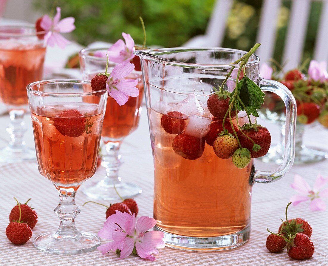 Erdbeergetränk mit Eiswürfeln, frischen Erdbeeren und Malven