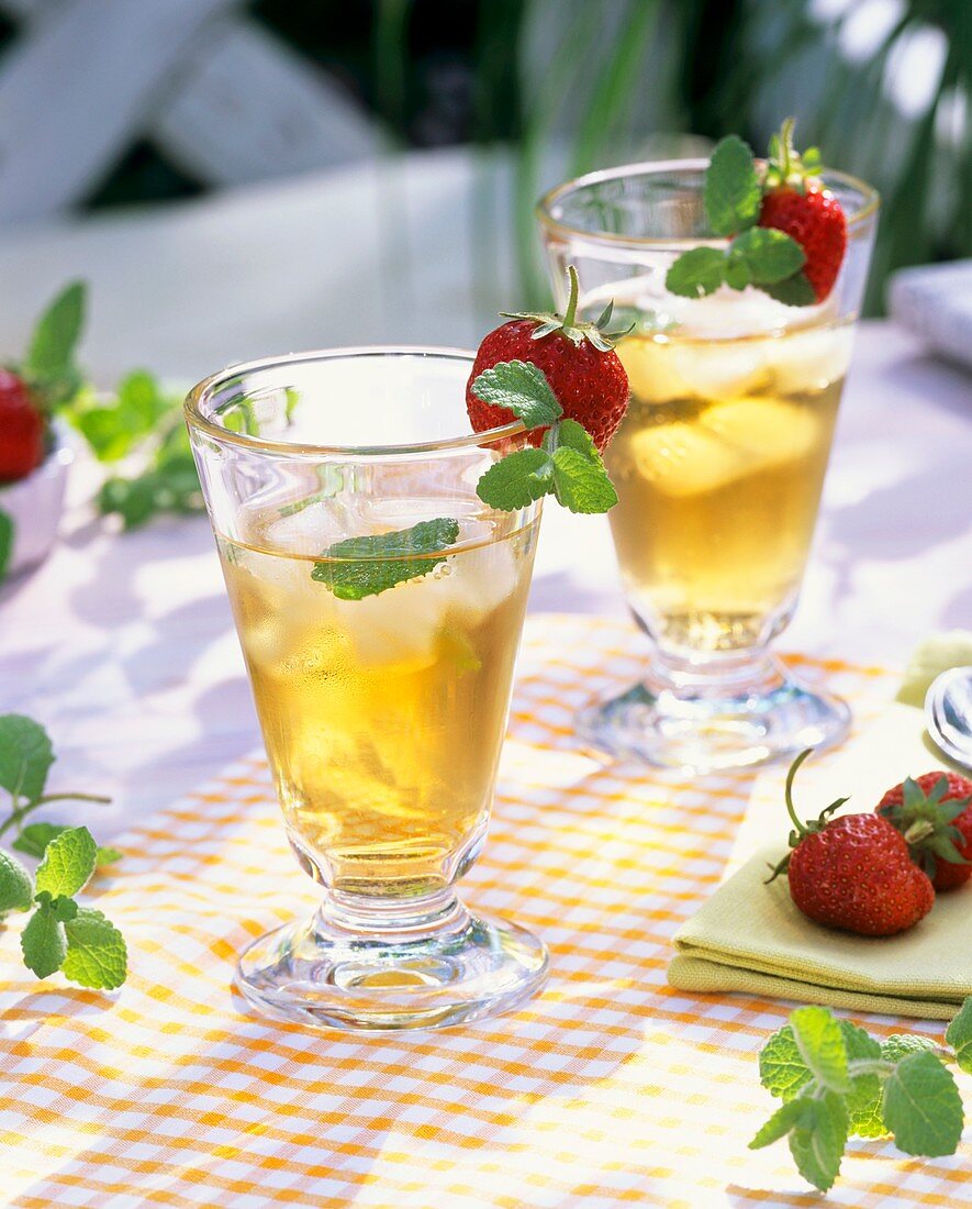 Eistee mit Erdbeerminze und frischen Erdbeeren an Glas