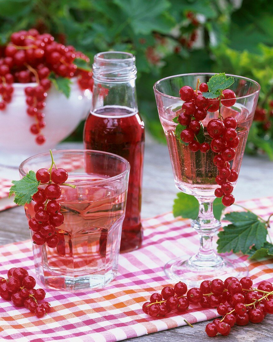 Redcurrant syrup in bottles & diluted with water in glasses