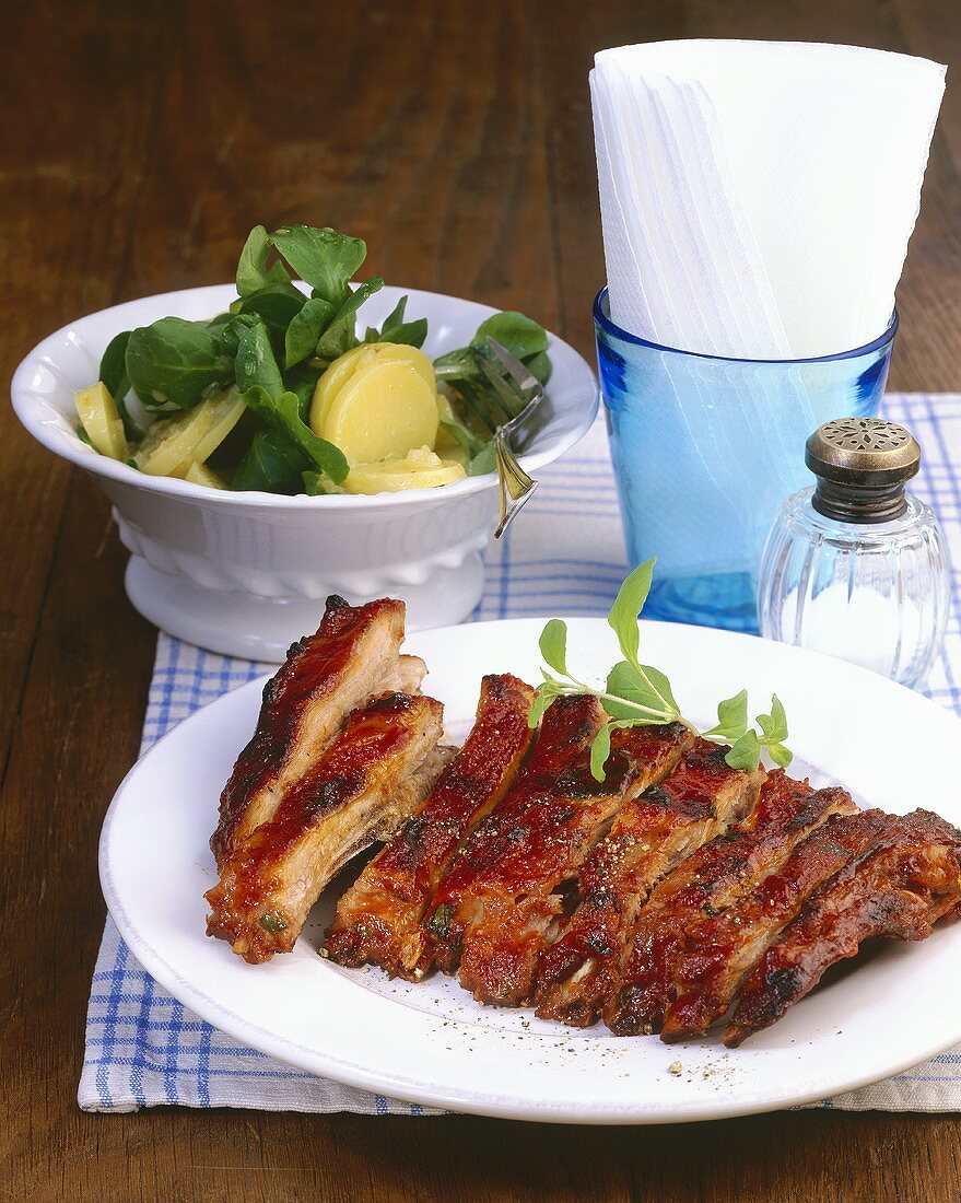 Spicy grilled pork ribs with corn salad and potato salad