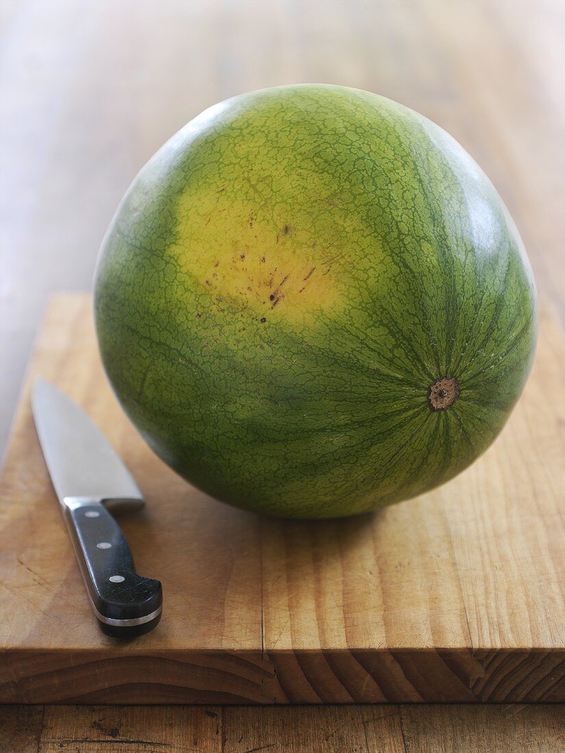 A watermelon with a knife