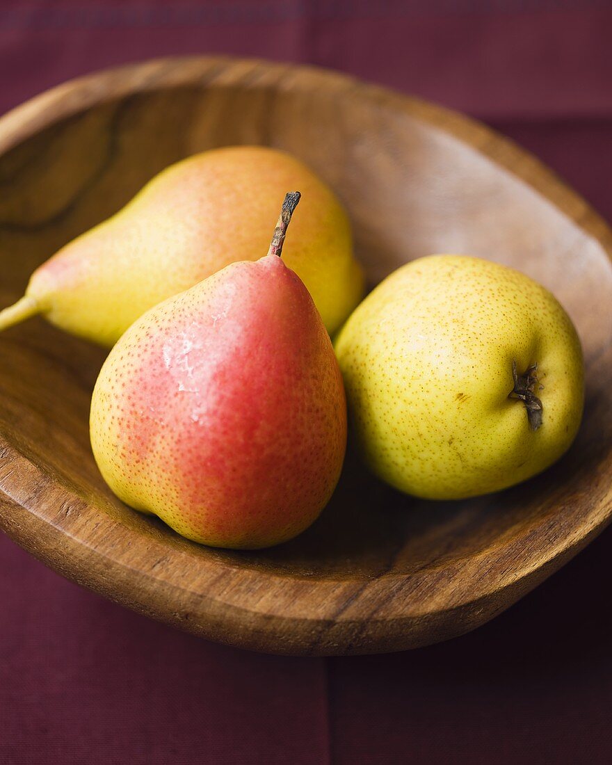 Three pears in a wooden bowl