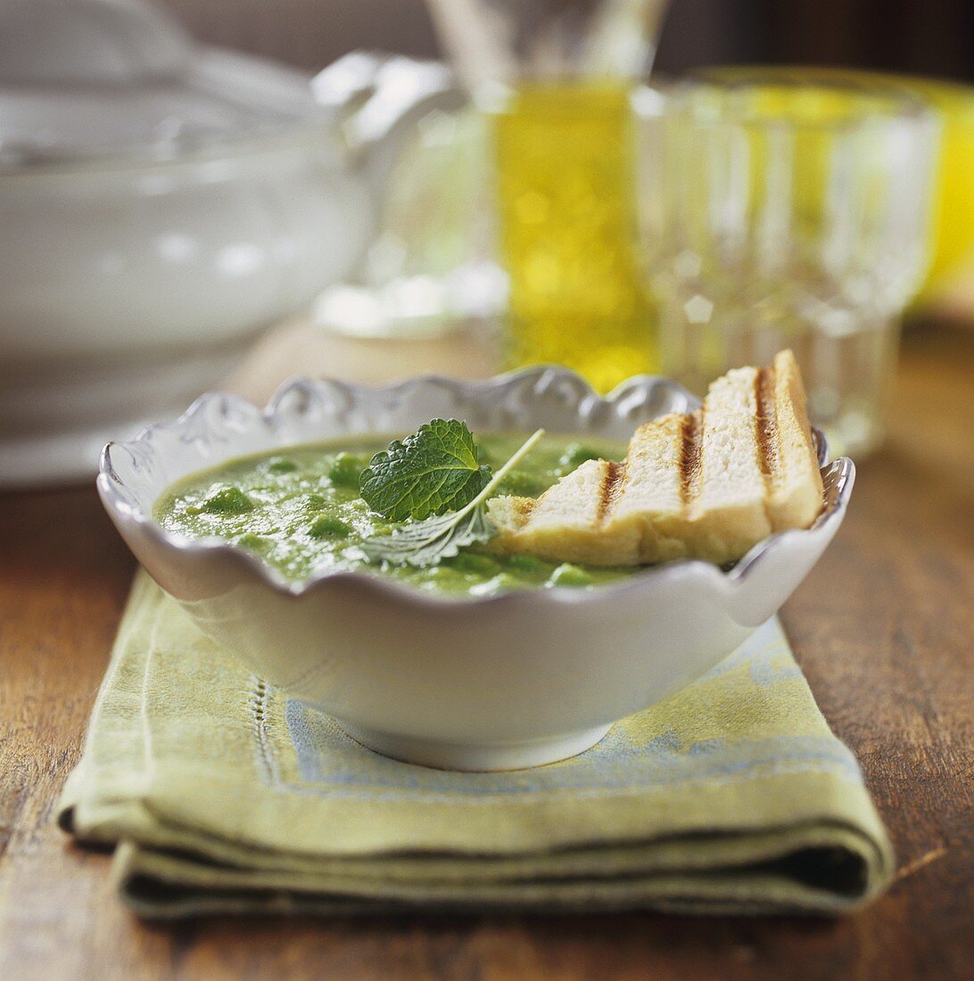 Pea soup with mint leaves and toast