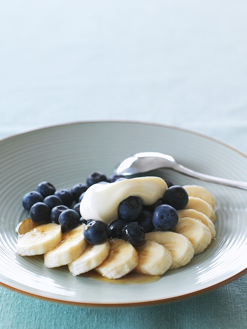 Banana and blueberry dessert with honey and cream