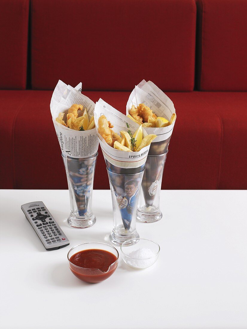 Fish and chips in newspaper and remote control
