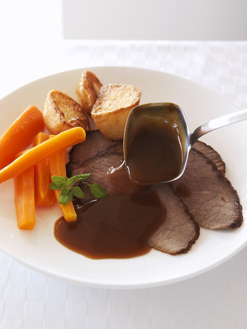 Roast beef with gravy, carrots and potatoes
