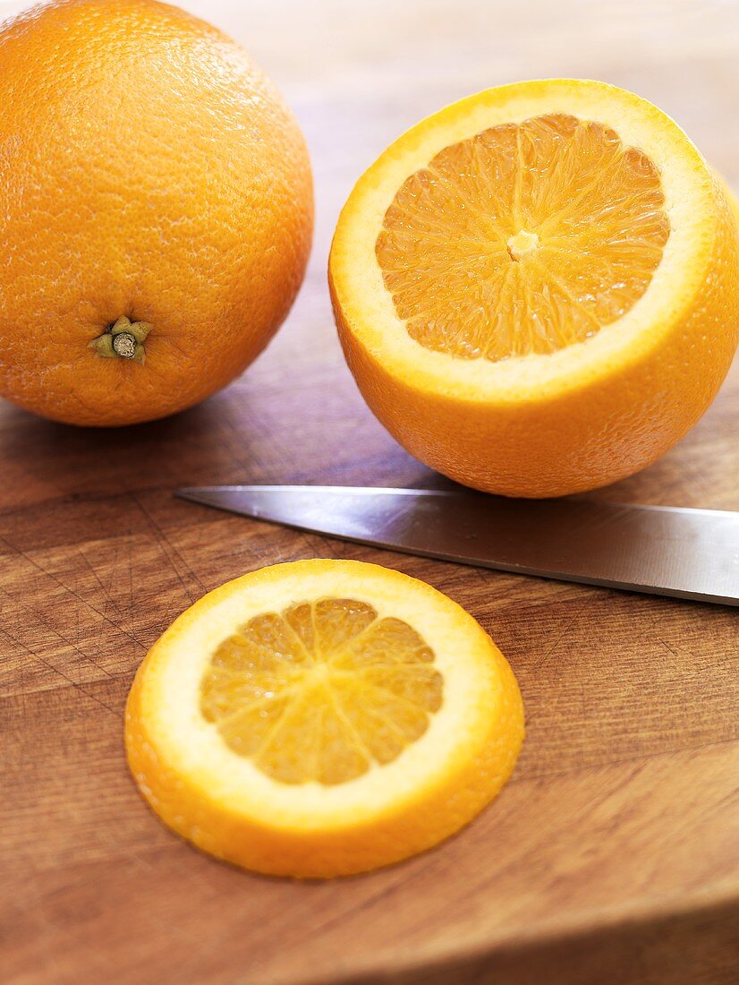 Orangen, ganz und angeschnitten
