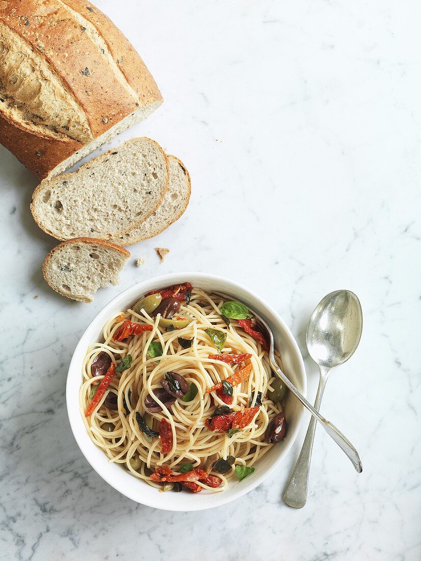 Spaghetti with olives, dried tomatoes and basil