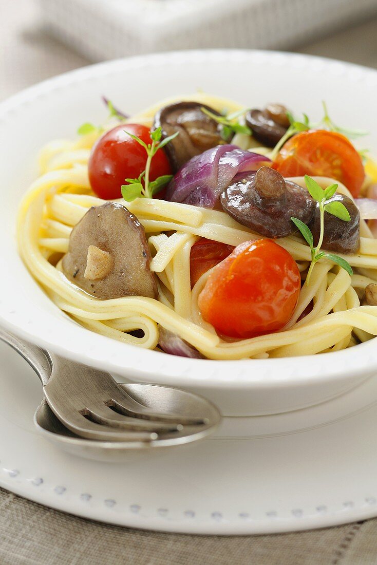 Ribbon pasta with tomatoes, onions and mushrooms
