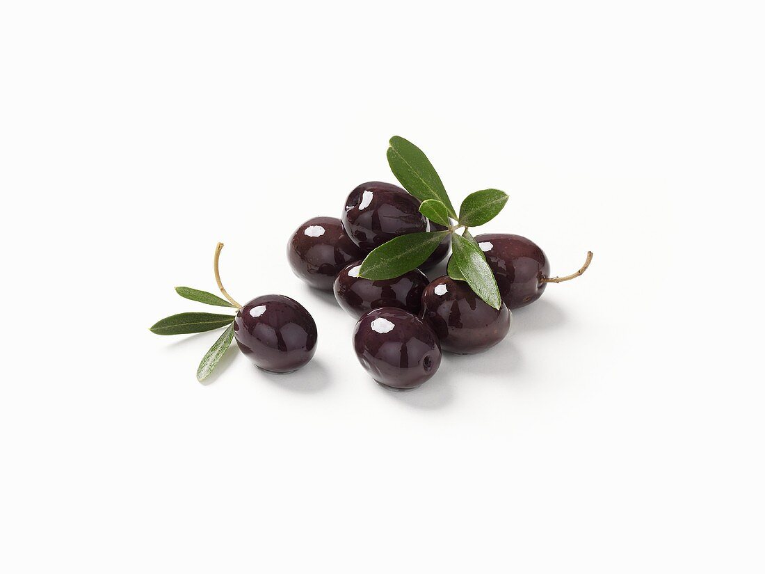 Schwarze Oliven und Olivenblätter