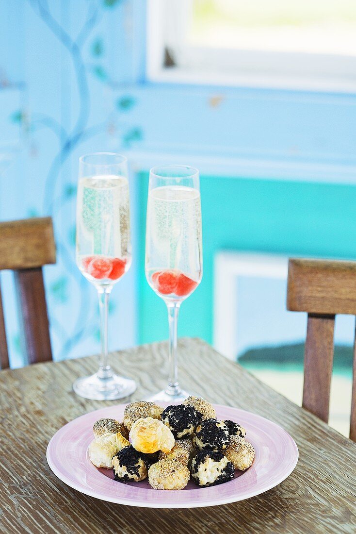 Small poppy seed & sesame pastries with two glasses of champagne