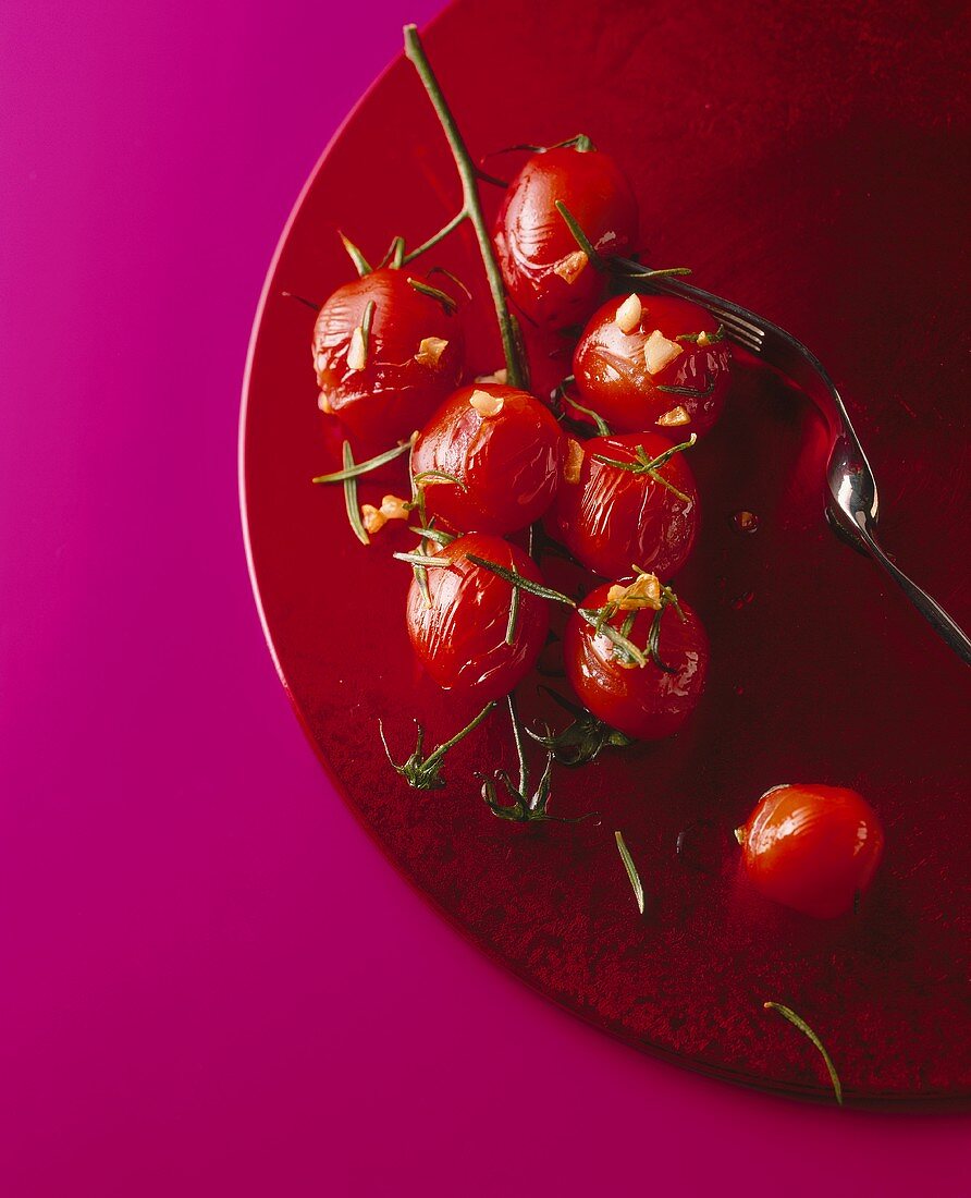 Grilled cocktail tomatoes on red plate