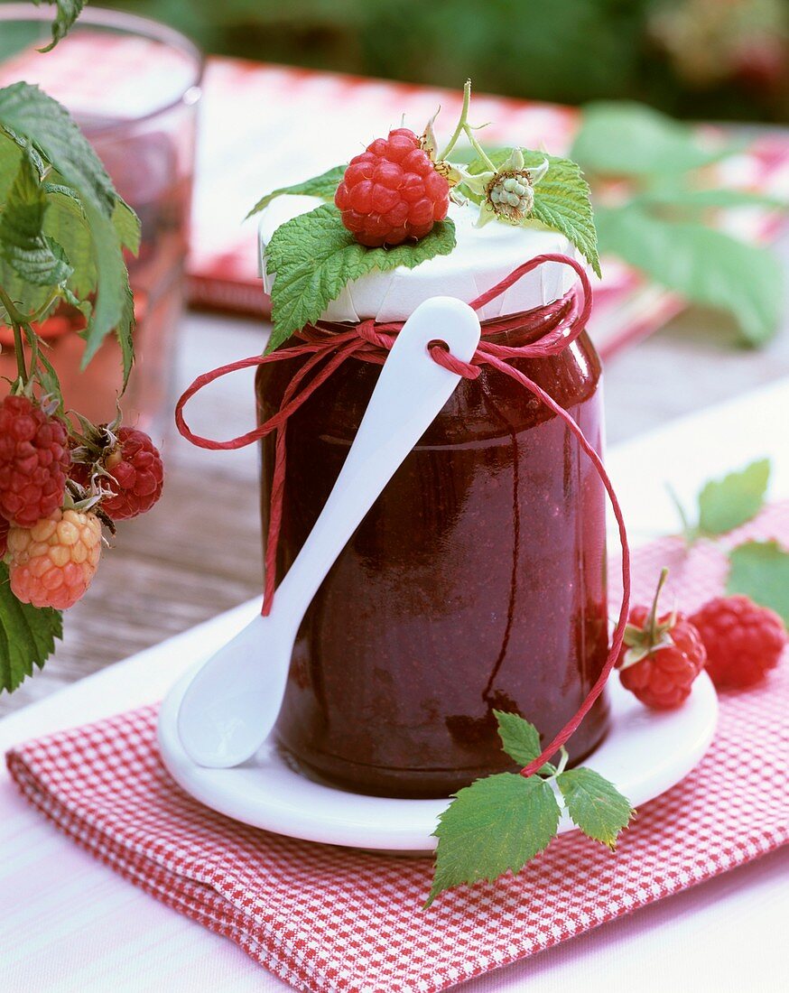 Raspberry jam decorated with fresh raspberries and spoon