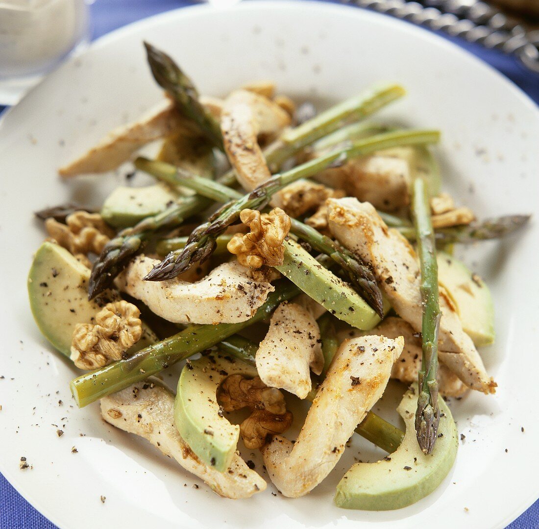 Avocado, chicken and green asparagus salad with walnuts