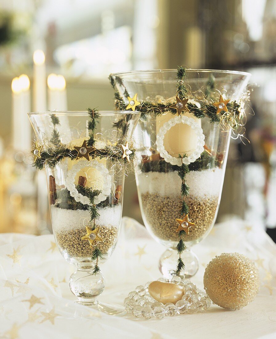 Candles in glasses decorated for Christmas