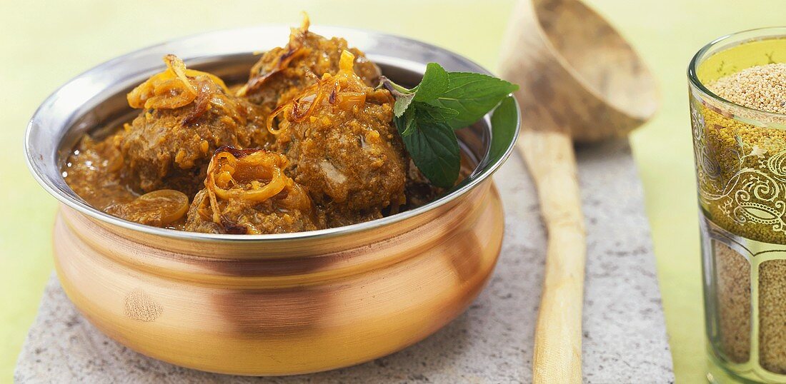 Meatballs with poppy seeds and coconut in onion sauce