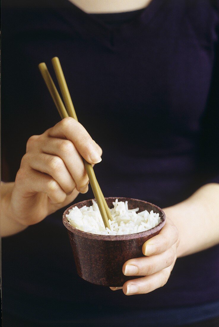 Reis mit Stäbchen essen
