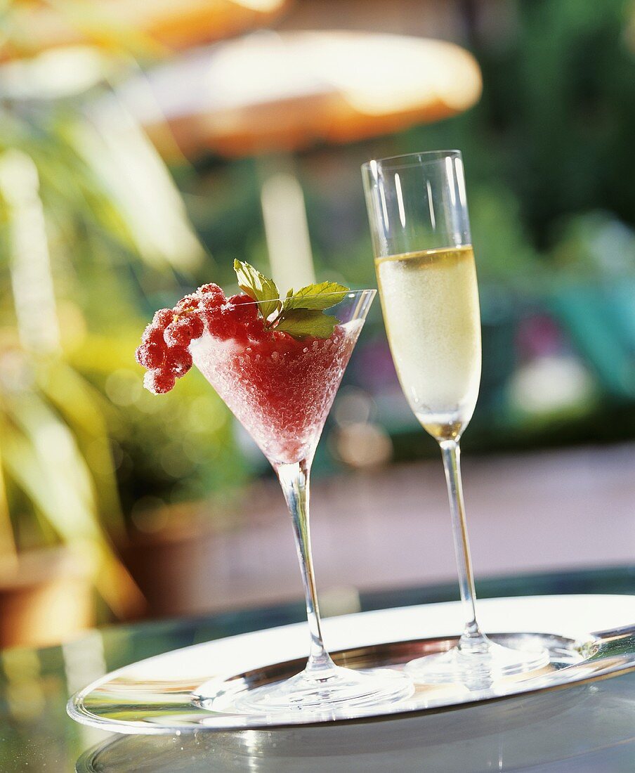 Fruity redcurrant drink and a glass of sparkling wine