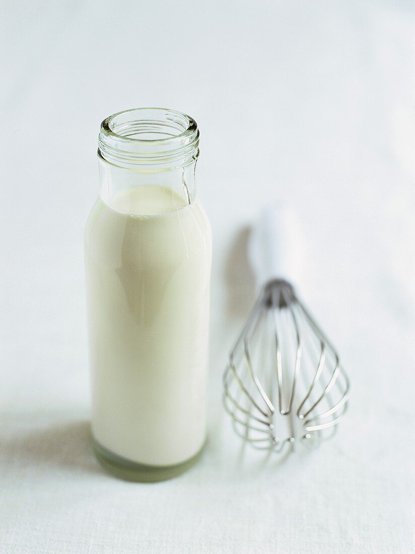 Bottle of cream and whisk