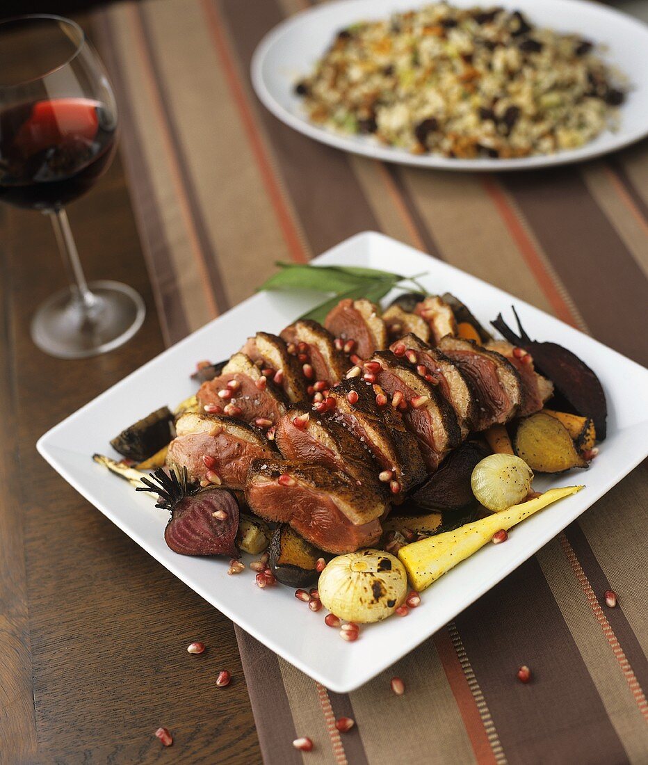 Duck breast with pomegranate seeds and roasted vegetables