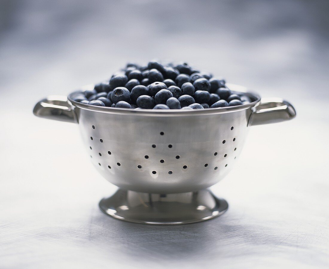 Fresh blueberries in a metal colander