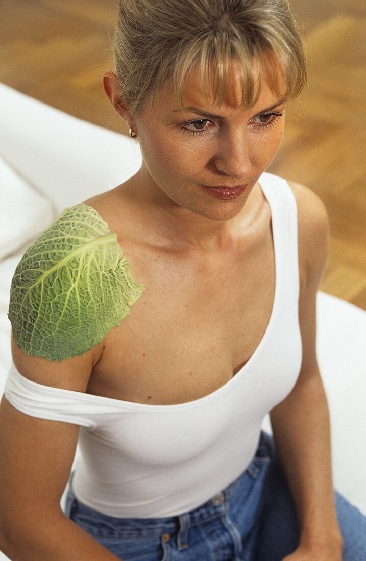 Young woman with cabbage compress on her shoulder