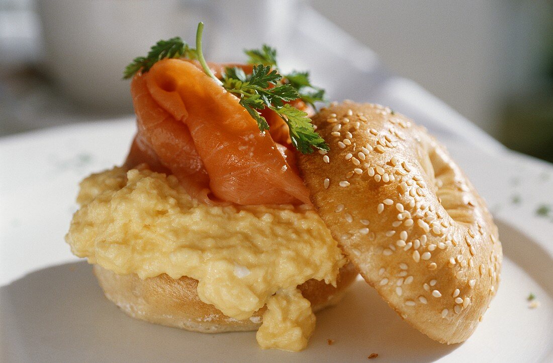 A bagel with scrambled eggs and salmon
