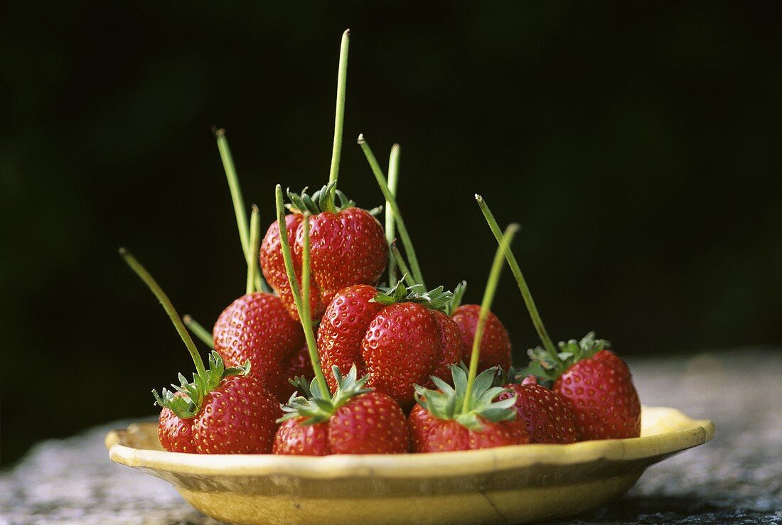 Fresh strawberries with stalks on a plate