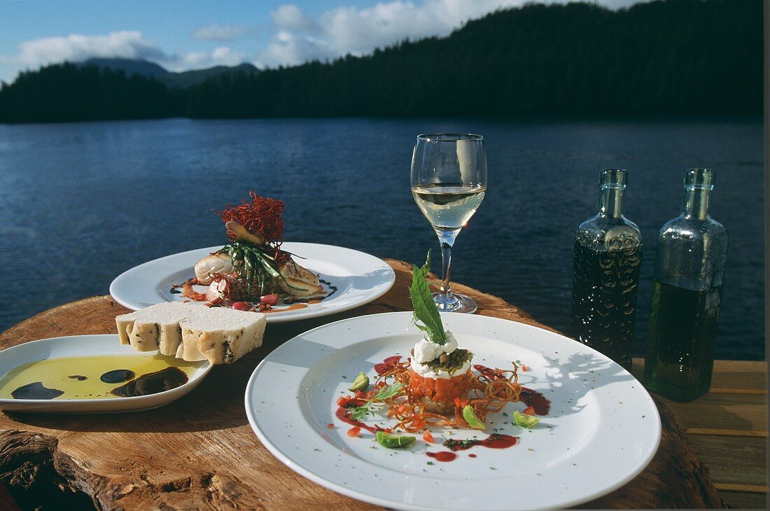 Zwei Fischgerichte auf Baumstumpf am See