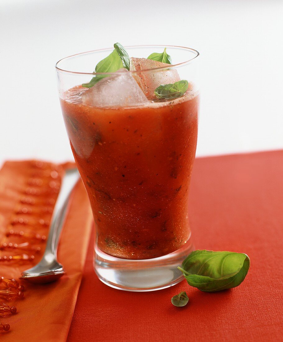 A tomato and basil drink over ice