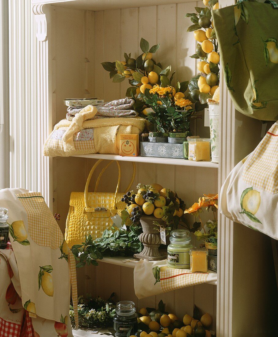 A shelf with garden and patio decorations (lemons, candles etc)