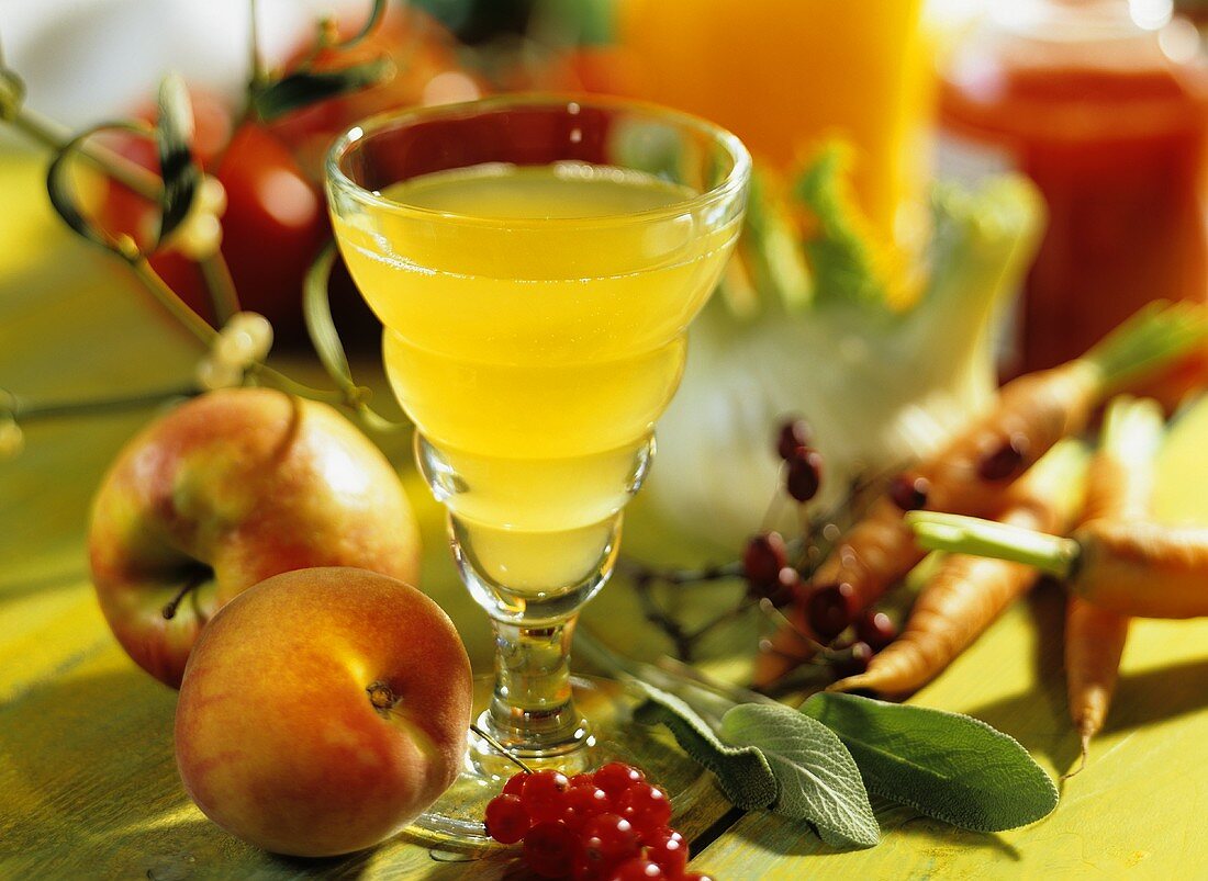 Stillleben mit Obstsaft, Obst, Gemüse und Kräutern