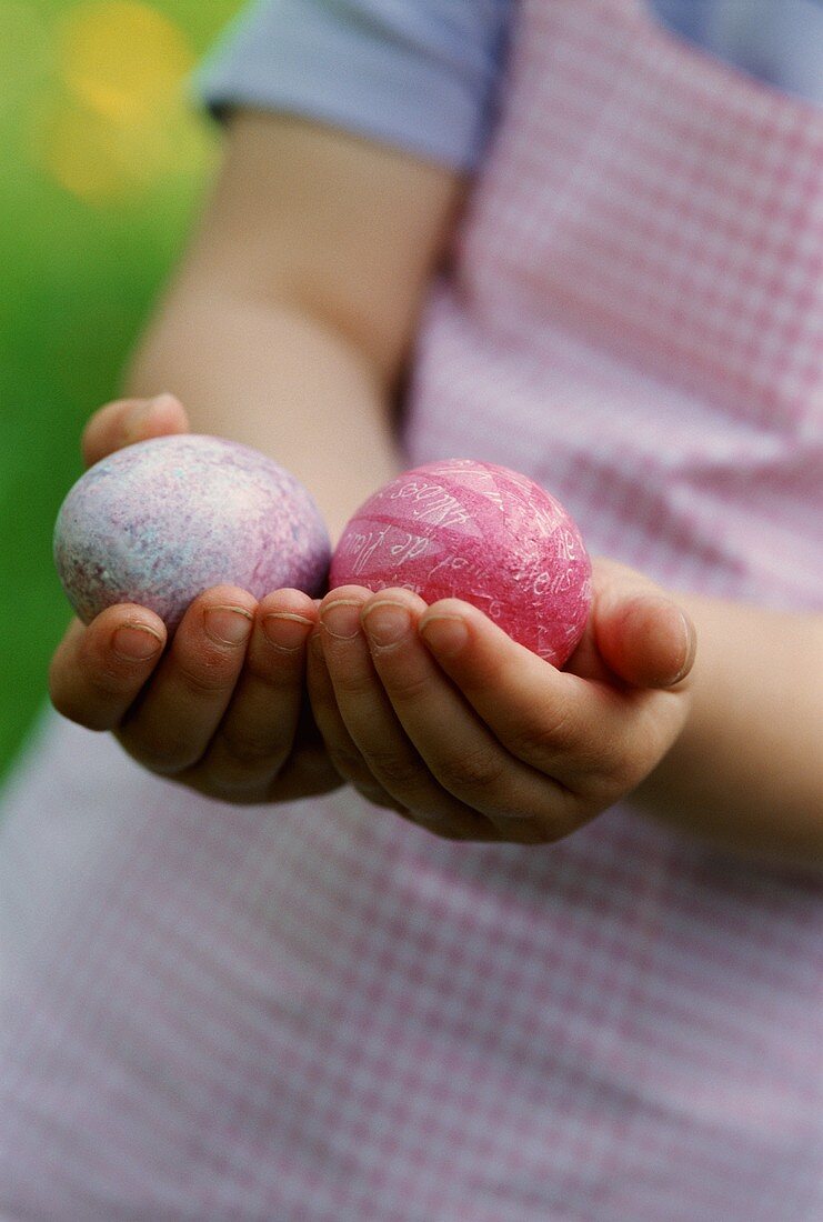 A girl holding two Easter eggs