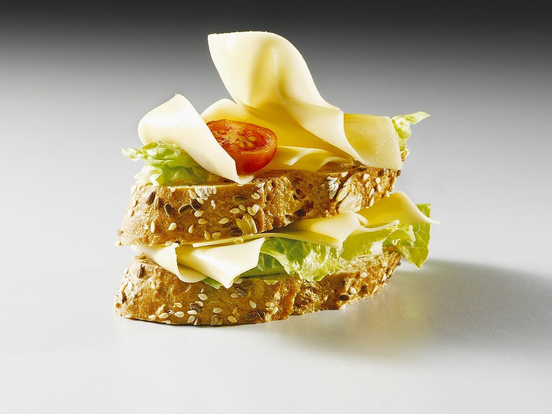 Slices of bread topped with cheese, lettuce and tomato