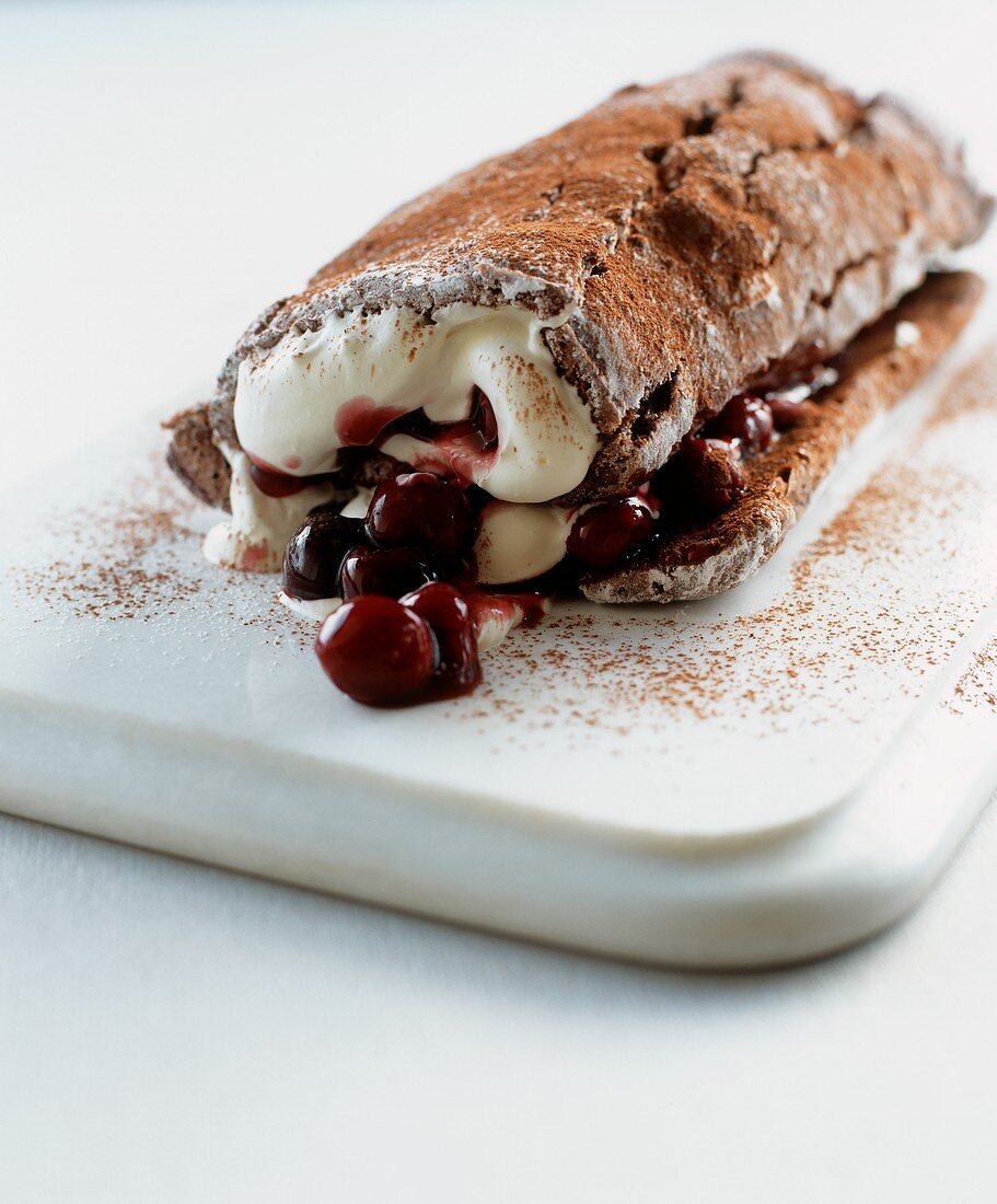 A chocolate Swiss roll filled with cherries and cream