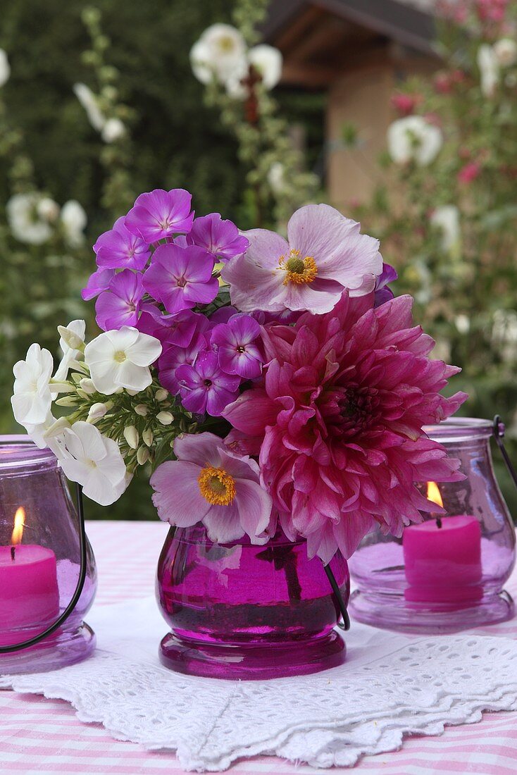 A pink bouquet and lanterns on a garden table
