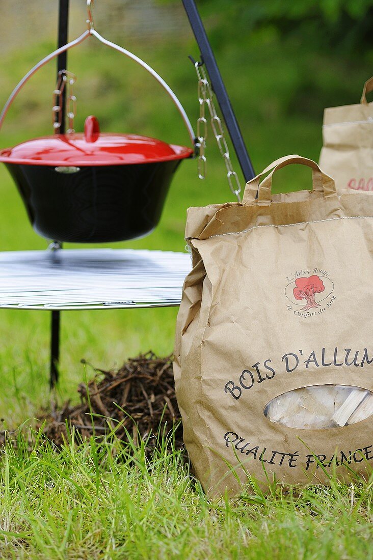 A cooking pot and a paper bag of coal