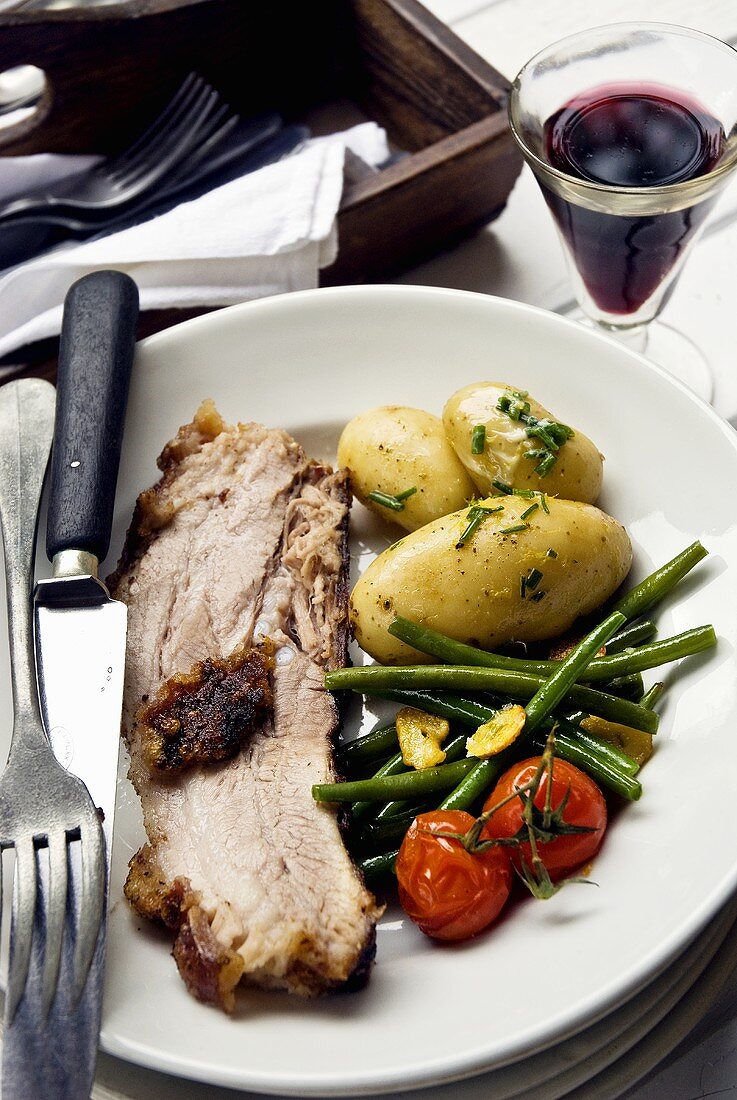Roast pork with potatoes and a side of vegetables