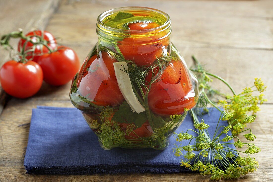 A jar of tomatoes and herbs in oil