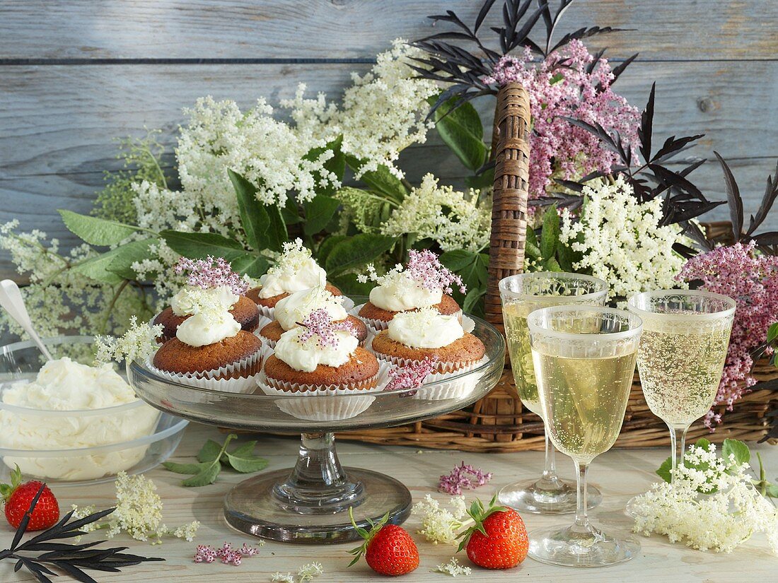 An arrangement of elderflower cakes, elderflower wine and elderflowers