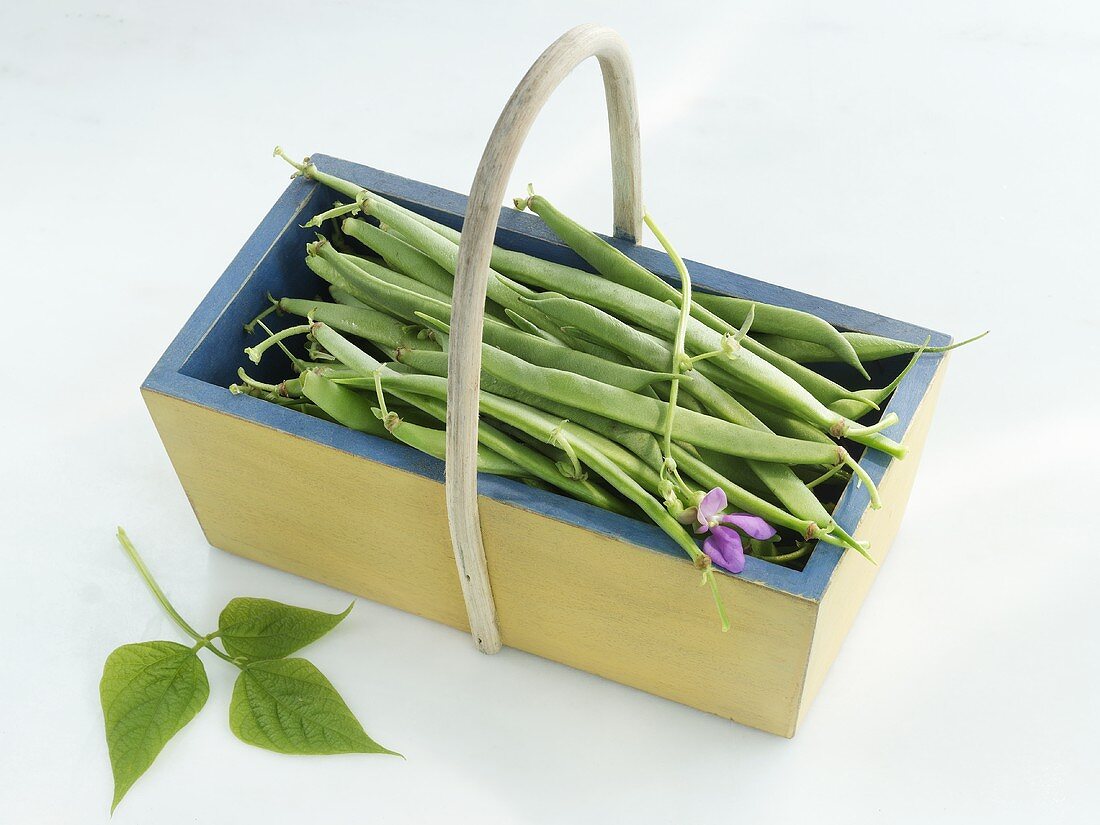 A wooden basket of French beans