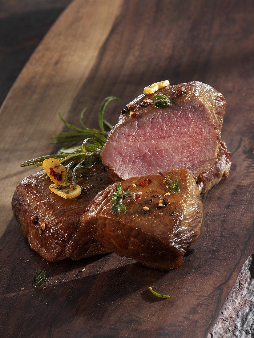 Roast saddle of lamb on a wooden board