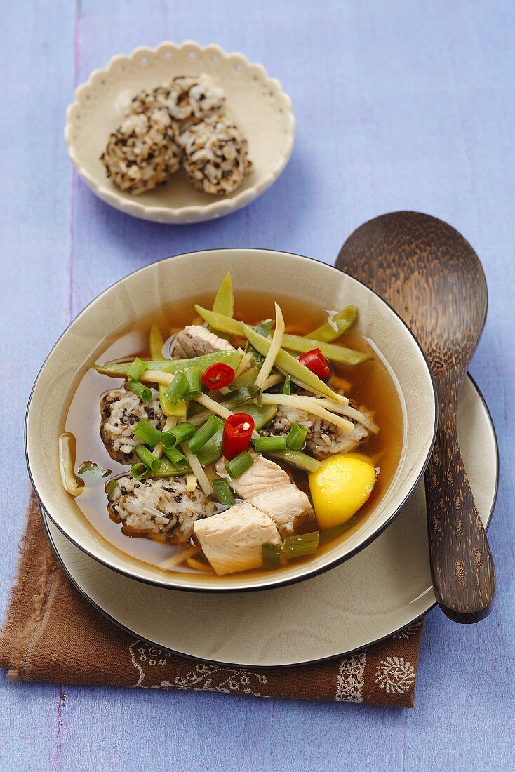 Broth with salmon, rice balls, bamboo and vegetables