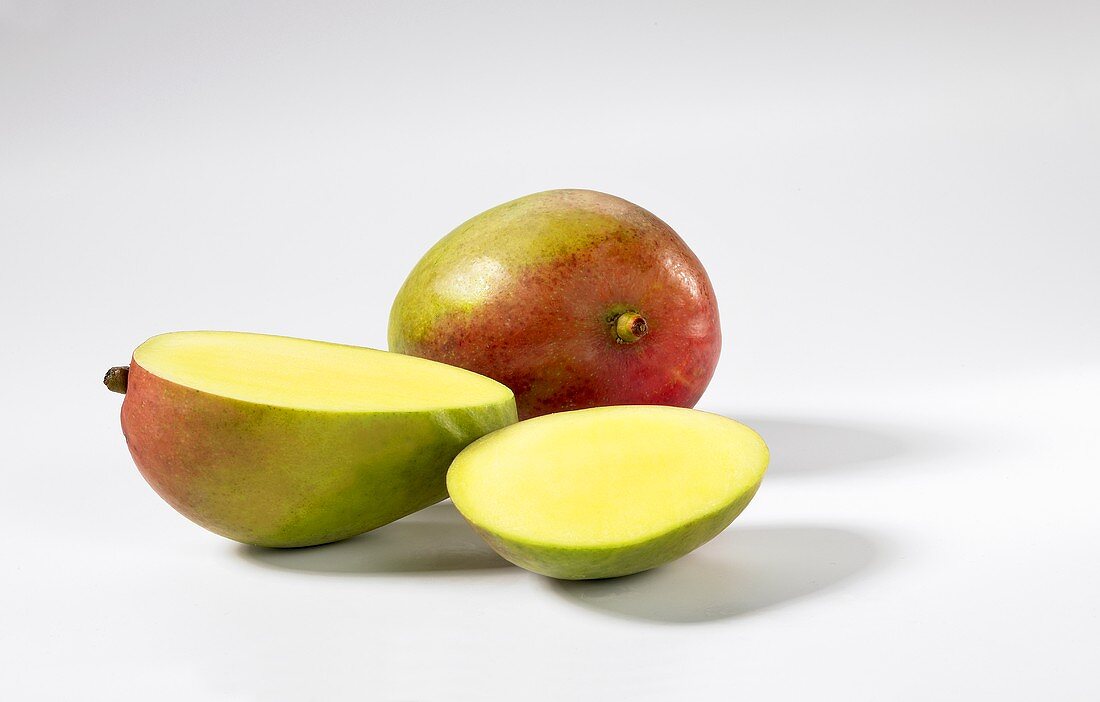 Two mangos, whole and sliced