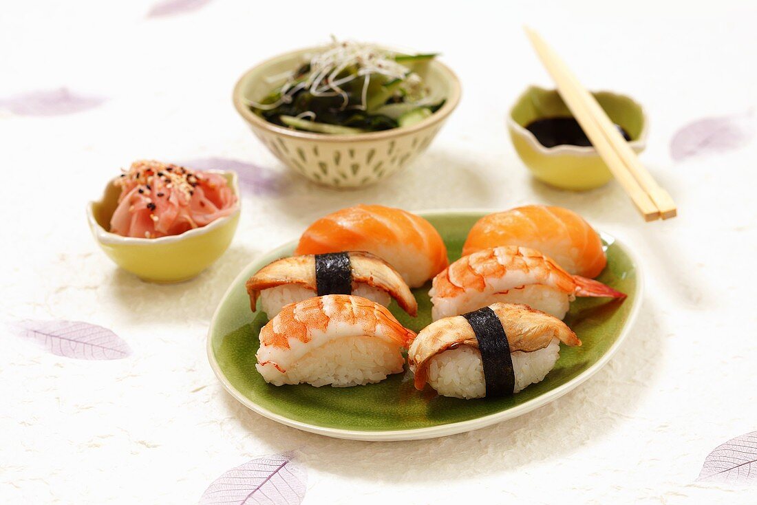 Nigiri sushi with salmon, eel and prawns, pickled ginger and seaweed salad