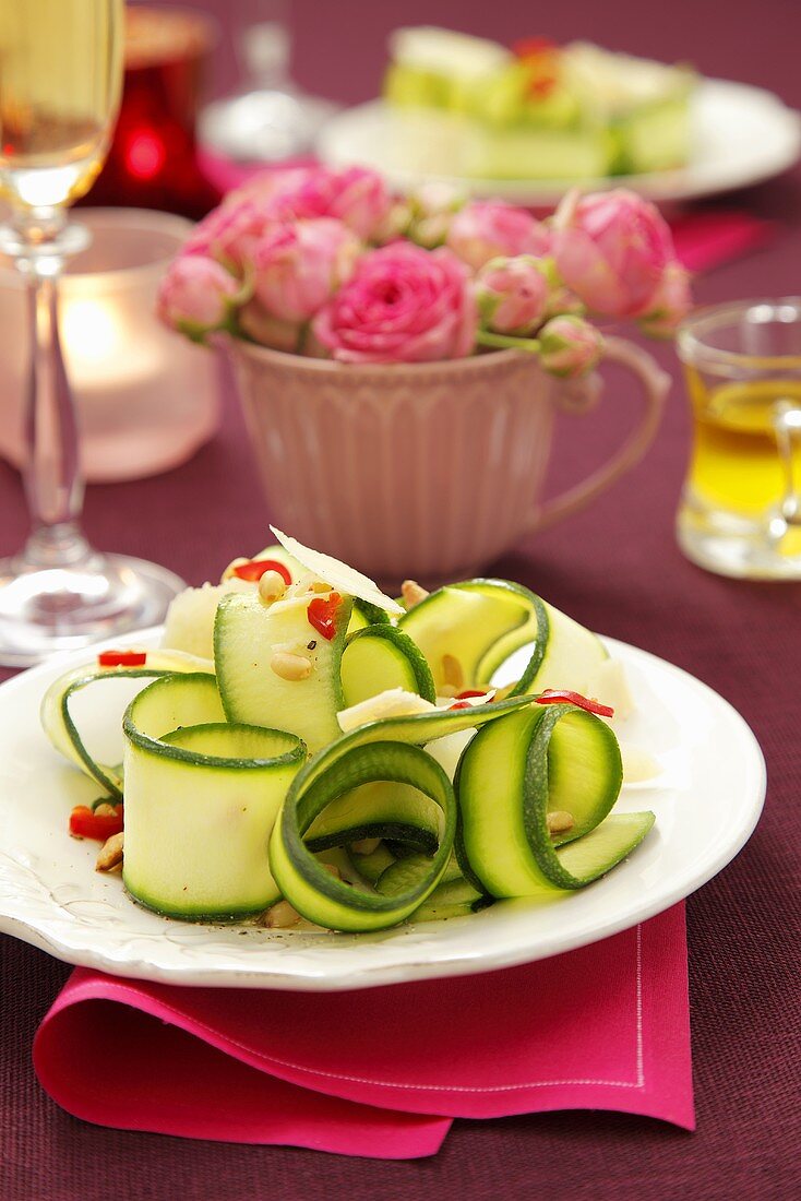 Zucchinistreifen mit Chili und Pinienkernen