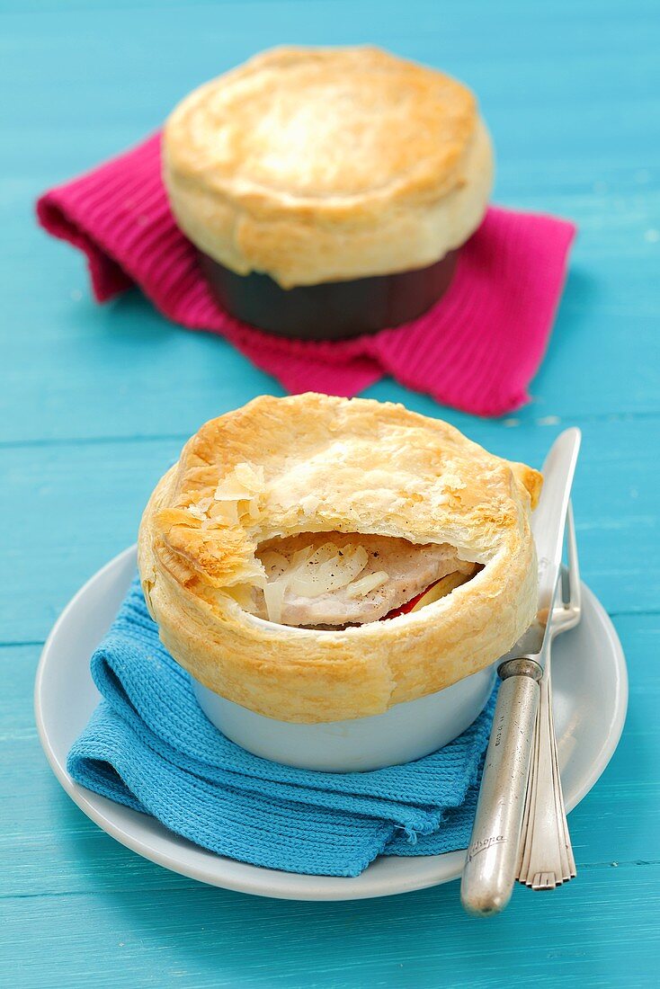Pork with onions and apples with a puff pastry topping