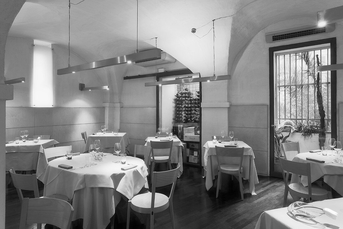 A black and white photo of a designer restaurant with a vaulted ceiling